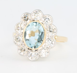 An 18ct yellow gold oval aquamarine and diamond cluster ring, the centre stone approx 1.5 carat surrounded by 10 brilliant cut diamonds, approx 1.8 carat, size O