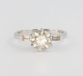 An 18ct white gold brilliant cut diamond ring, approx 1.5ct, flanked by tapered baguettes, size M 1/2