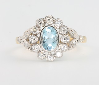 An 18ct yellow gold aquamarine and diamond cluster ring, the centre stone approx 1.0ct,size R