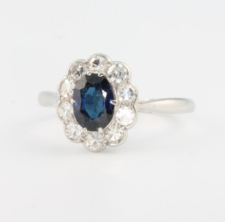 An 18ct yellow gold oval sapphire and diamond cluster ring, the centre stone approx 0.75ct surrounded by 10 brilliant diamonds, each approx 0.05ct, size N