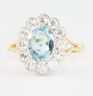 An 18ct yellow gold aquamarine and diamond cluster ring, the centre stone approx 0.8ct surrounded by 12 brilliant cut diamonds, size P