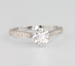 An 18ct white gold brilliant cut diamond ring, approx 1.0ct, the fancy claw set mount with brilliant cut diamonds, size M