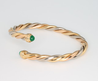 Cartier, an 18ct two colour gold rope twist bangle, cabochon emerald terminals, dated 1990 No 928440