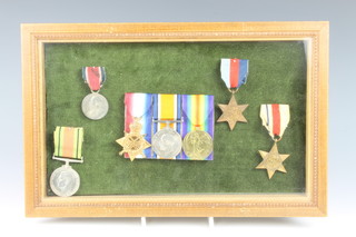 A WW1 trio (with names erased) a 1939-45 star, and Africa star and a Defence medal together with a school attendance medal, framed