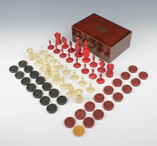 A 19th Century turned and stained bone chess set, King 3 3/4"h together with a set of draughts