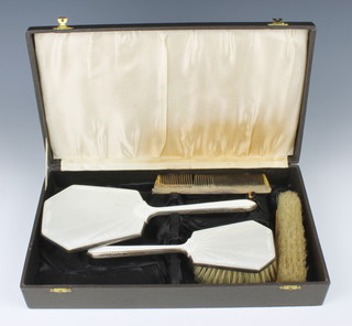 An Art Deco silver and champagne guilloche enamel cased brush set comprising mirror, hairbrush and clothes brush, together with a silver comb, Birmingham 1939