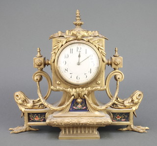A 19th Century French 8 day timepiece with enamelled dial and Arabic numerals, contained in a gilt metal case surmounted by an urn and with champleve enamelled panels to the base, raised on 2 tallen supports 