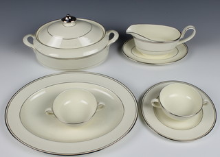 An 80 piece Minton Bridal Veil pattern dinner service comprising 3 oval tureens and covers 9", an oval meat plate, 3 oval meat plates 13 1/2", 3 sauce boats and stands, 14 twin handled soup bowls and saucers 14  dinner plates 10 1/2", 14 side plates 8",  14  bowls 5 1/2"