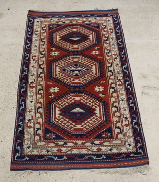 A tan, blue and white ground Caucasian style rug with three diamonds to the centre within multi row borders 87 1/2" x 50"