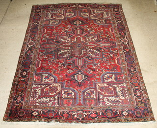 A red and blue ground Persian Heriz carpet, some wear and moth 134" x 98"