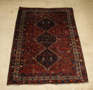 A red and blue ground Persian Qashqai rug with 3 medallions to the centre, some wear