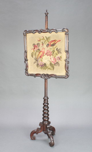 A Victorian turned mahogany pole screen, the square Berlin woolwork panel decorated birds amidst branches 23"h x 22 1/2" raised on a bobbin turned stand on tripod support