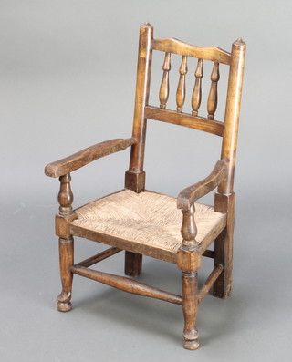 A Victorian elm spindle back childs carver chair with woven rush seat 