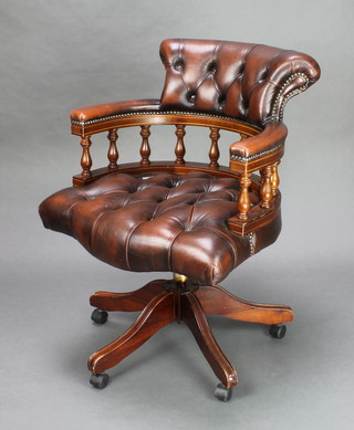 A tub back revolving office chair upholstered in brown button back leather