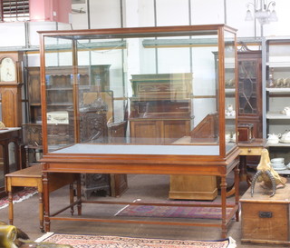 An Edwardian rectangular glass and mahogany museum quality display cabinet raised on 4 square tapered supports with box framed stretcher ending in spade feet 84"h x 77"w x 37 1/2"d