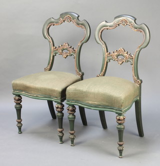 A pair of Victorian green and gilt painted salon style chairs with carved and shaped mid rails, the seats of serpentine outline, upholstered in green material