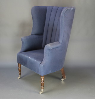 A Georgian style tub back library chair upholstered in blue material raised on turned supports 