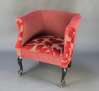 A late Victorian tub back chair upholstered in red material, raised on cabriole supports
