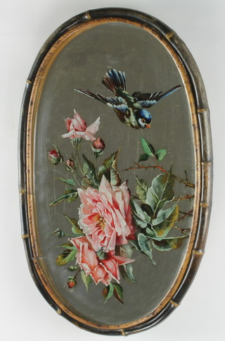 A Victorian oval bevelled plate mirror, the reverse painted a bird and rose contained in a bamboo frame 20 1/2"h x 13"w