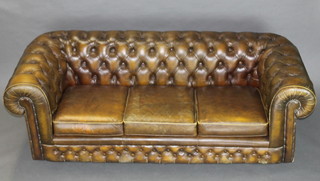 A Chesterfield upholstered in green button back leather 27"h x 79"w x 33"d