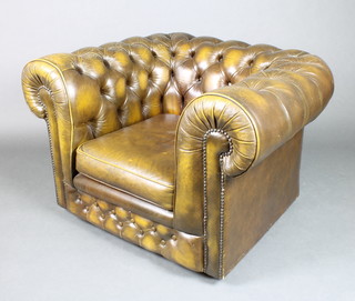 A Chesterfield style armchair upholstered in green button back leather 70"h x 40"w x 33"d