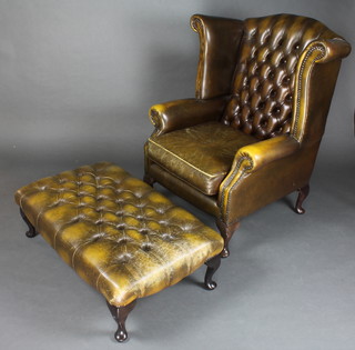 A Georgian style winged armchair upholstered in green button back leather 47"h x 34"w x 26"d together with a rectangular footstool upholstered in green buttoned leather raised on cabriole supports 12"h x 37"w x 22"d