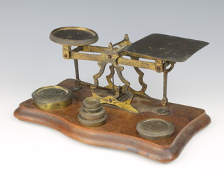 Criterion, a pair of gilt metal postage scales raised on a shaped mahogany base together with 6 graduated weights 