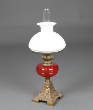 A Victorian opaque orange glass oil lamp reservoir  raised on a pressed metal base with opaque shade and chimney 47cm h  