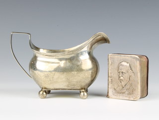 A Georgian silver cream jug raised on bun feet London 1808 108 grams, together with a miniature volume "The Works of Alfred Lord Tennyson" with repousse silver cover 