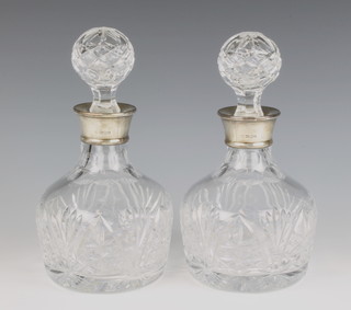 A pair of cut glass mallet shaped decanters and stoppers with silver collars Birmingham 1990 23.5cm 