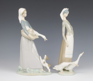 A Lladro figures of a standing girl with goose and puppy 28cm and 1 other of a standing girl with goose 26cm (stick possibly missing from hand) 
