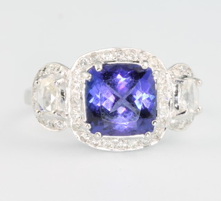 An 18ct white gold tanzanite and diamond ring, the cushion cut centre stone approx 2.84ct surrounded by brilliant and cushion cut diamonds approx 0.60ct, size N