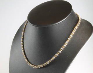 An 18ct 2 colour gold diamond set necklace, set with 57 brilliant cut diamonds in a rub over setting 16 1/2", a do. bracelet set with 24 brilliant cut diamonds 7" 