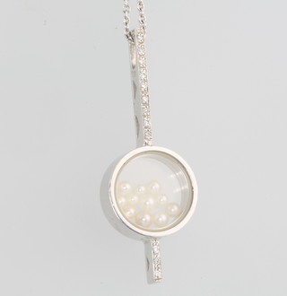 An 18ct white gold diamond and floating seed pearl pendant on a ditto chain 