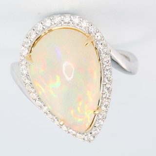 An 18ct white gold pear cut opal and diamond cluster ring, the centre stone approx 4.4ct surrounded by brilliant cut diamonds, approx 0.34ct, size M 1/2