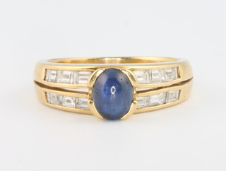 A yellow gold cabochon cut sapphire and baguette cut diamond ring, size P