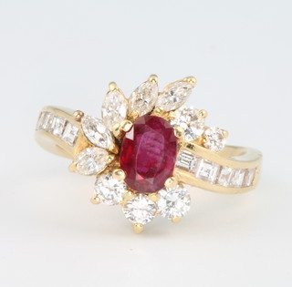 An 18ct yellow gold oval ruby and diamond cluster ring size L 1/2