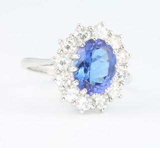 An 18ct white gold oval tanzanite and diamond ring, the centre stone approx. 2.8ct surrounded by 12 brilliant cut diamonds approx. 1.3ct, size P