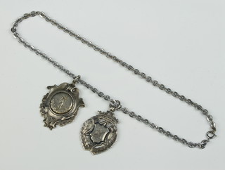Two silver sports fobs on a chromium chain 