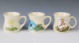 Two Moorcroft waisted mugs with decorated flowers,impressed Moorcroft to base together with a similar mug marked Haxted