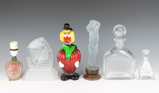 A Murano glass figure of a clown and a frosted glass figure of a standing semi-naked lady, a paperweight with etched decoration of a dragon, a spirit decanter with an etched panel decorated a dragon, a scent bottle and a scent bottle converted for use as a table lamp 
