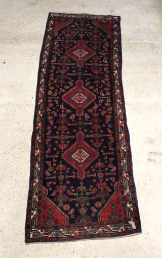 A blue and red ground Bakhtiari runner with 3 stylised diamonds to the centre 330cm x 103cm", some flecking