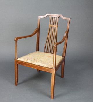 An Edwardian inlaid mahogany open arm chair raised on square tapering supports with upholstered drop in seat