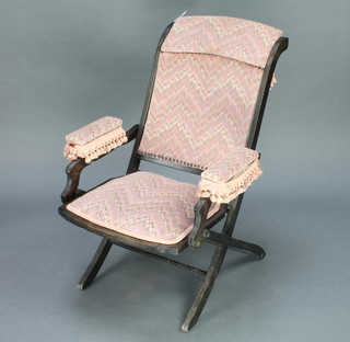A Victorian ebonised folding sewing/campaign chair upholstered in pink patterned material