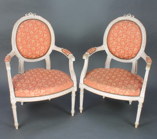 A pair of French style limewood open arm salon chairs with upholstered seats and backs raised on turned and fluted supports 