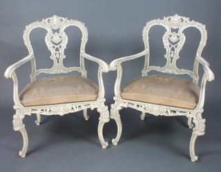 A pair of French grey painted open arm salon chairs with pierced vase shaped splat back and upholstered seats raised on carved cabriole supports 