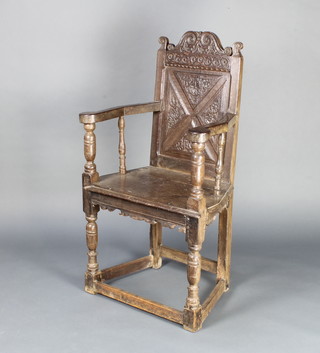 A 17th/18th Century oak Wainscot chair with carved panelled back and solid seat, having a carved and shaped apron, raised on turned and block supports  110cm h x 43cm w 