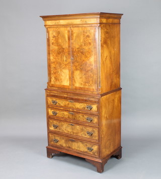A Queen Anne style figured walnut and crossbanded cocktail cabinet, the upper section with moulded cornice having fluted columns to the side enclosed by panelled doors, the base fitted a brushing slide above 4 long drawers raised on bracket feet 152cm h x 71cm w x 43cm d 