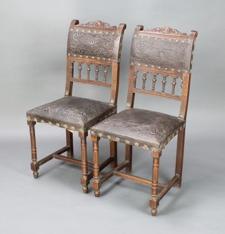 A pair of French Continental hall chairs with bobbin turned decoration, the seats and backs upholstered in leather, raised on turned supports with box framed stretcher 