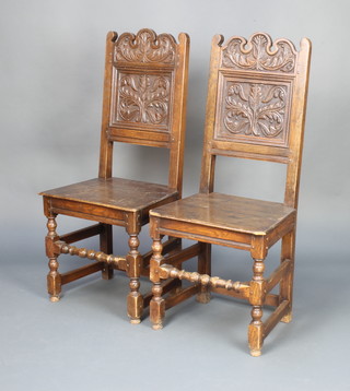 A pair of 17th Century style carved oak hall chairs with solid seats,  raised on turned and block supports 
